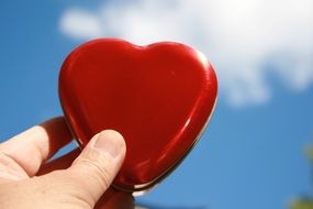 red heart shaped box in man's hand