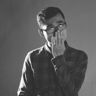 portrait of a young man with a hand on his face