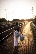 girl at sunset goes near the railway