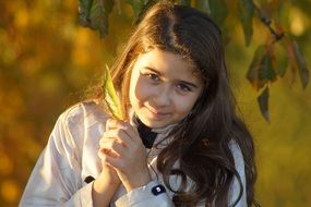 Portrait of nice Child girl posing with leaf