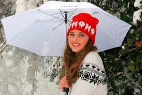 girl in a red hat under an umbrella