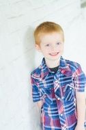 smiling caucasian Child Boy stands at wall