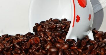 still life of coffee beans and cup with red hearts