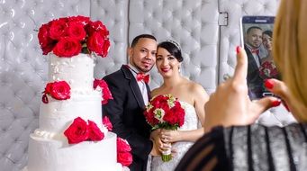 newlyweds posing near the wedding cake