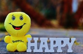 funny smiling soft toy holds white word Happy