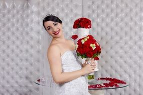 bride with a bouquet of red roses at a wedding