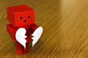 Red cardboard figure with a white torn heart