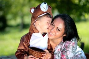 child in a bear costume kisses mom