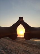 pair of legs against the setting sun