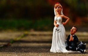 figure of the bride with handcuffs and the bridegroom at the feet