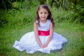 little girl in a white dress on green grass