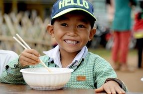 small boy eating noodles