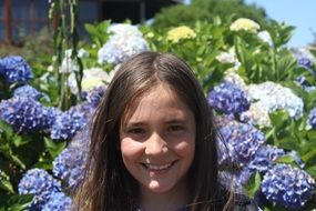 happy girl on a background of blooming lilacs