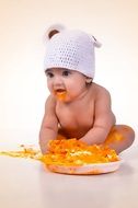 newborn and pumpkin puree on the floor