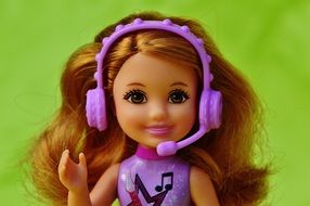 doll with lush hair in headphones with a microphone