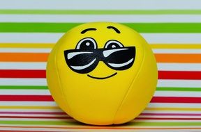 yellow ball with a playful smile in glasses