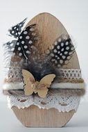 wooden easter egg with feathers and lace