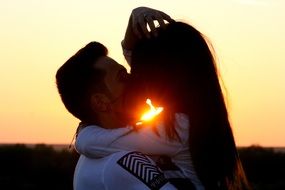 kiss of a young couple at sunset