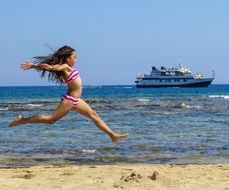 girl runs and jumps along the sea coast