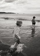 black and white photo of children in shallow water