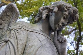 angel statue under a green tree