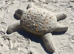 Turtle statue on a sand beach