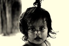 child with disheveled hair in black and white