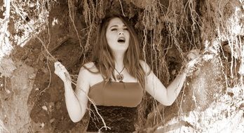 photo of girls on the background of the roots of a tree