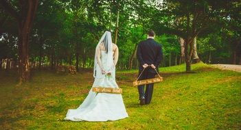 newlyweds on a swing in nature