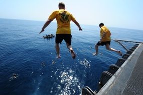 people are jumping into the ocean