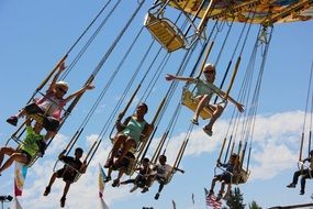 children on a carousel with chains in a theme park