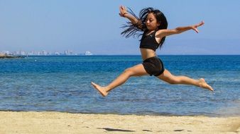 baby jumping on a sandy beach