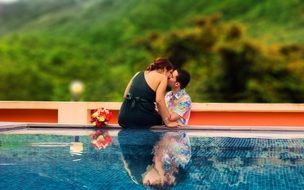 couple kissing by the pool