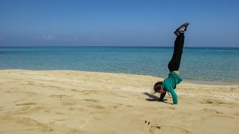 girl standing on her hands on the beach