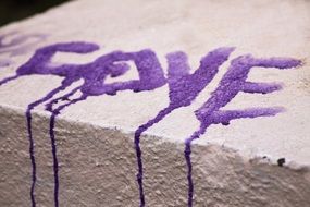 Beautiful purple lettering of love on white stone