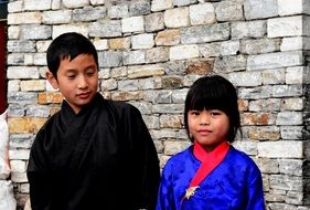 photo of asian sister and brother on stone wall background