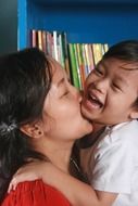 mom and son kissing and laughing
