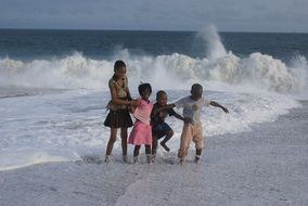 african kids in the spray of the ocean