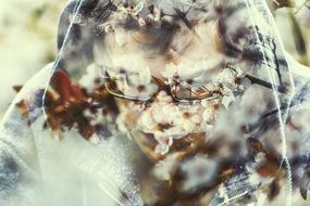 photo of a young man's face through a blooming garden