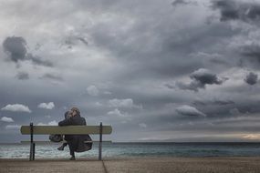 married couple sitting on a bench near the sea