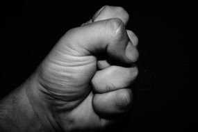 hand in a fist on black background