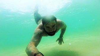 man is diving in blue water