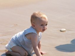 toddler sitting on the beach