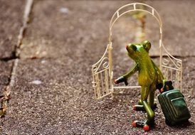 figure of a frog with a suitcase near the garden arch