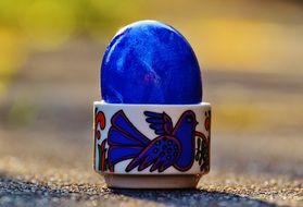 bright blue easter egg in stand