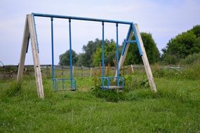 old swing among green grass