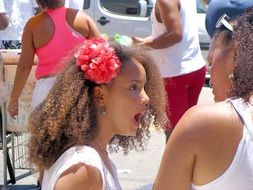 girl with a flower in her head talking to her mother