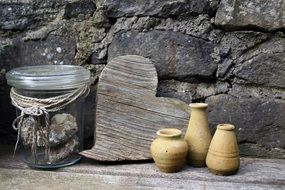 picture of the wooden heart and vases near a stone wall