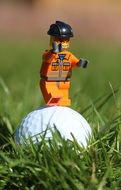 orange lego figure on the golf ball