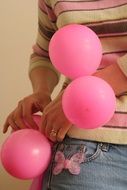 pink balloons in the hands of a woman